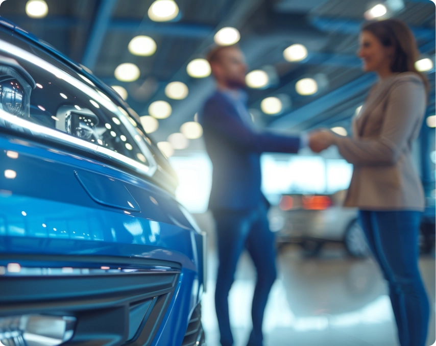 Man and woman shaking hands in car lot